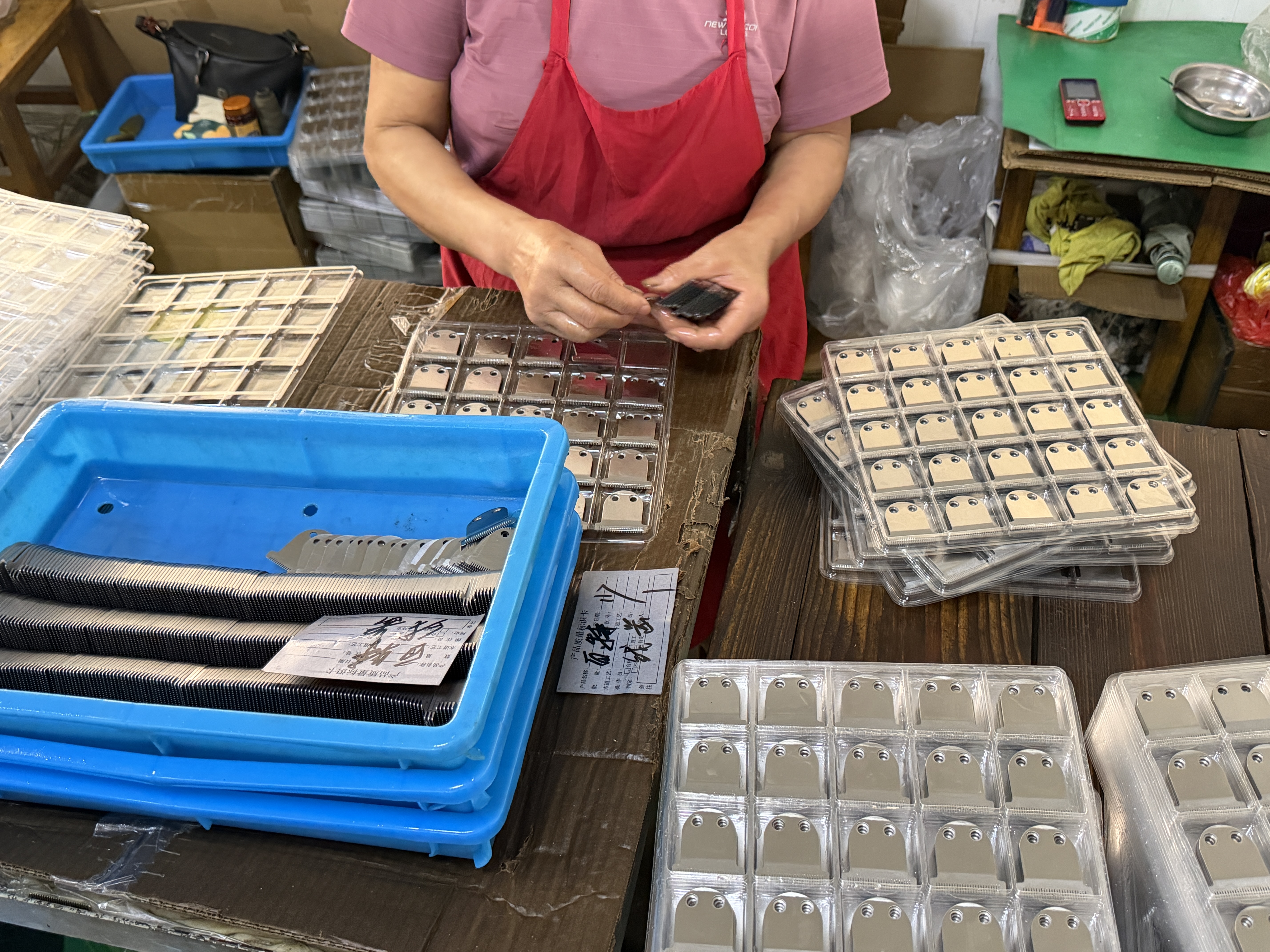 Worker inspecting clipper blades for quality control